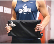Gronk Fitness Hip Thrust Pad for Barbell held by male athlete wearing Gronk Fitness tank top. 