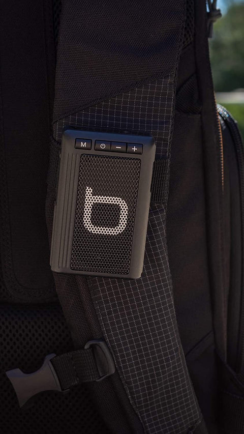 Black Bumpboxx Bluetooth Retro Pager Beeper clipped on backpack. 