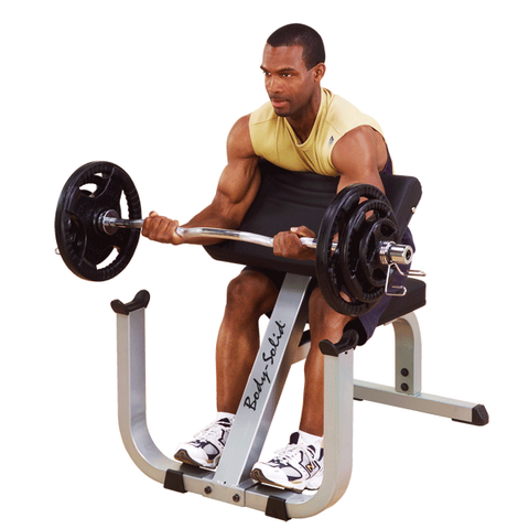 Male athlete uses Body-Solid GPCB329 Preacher Curl Bench for preacher curls.